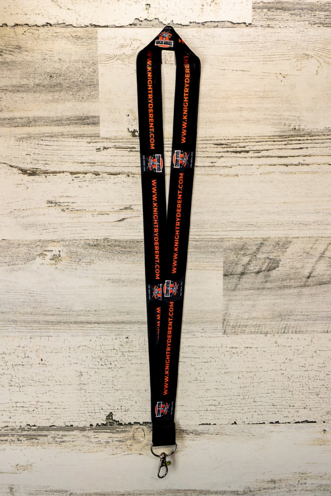 A pair of black and orange lanyards on top of a wooden table.
